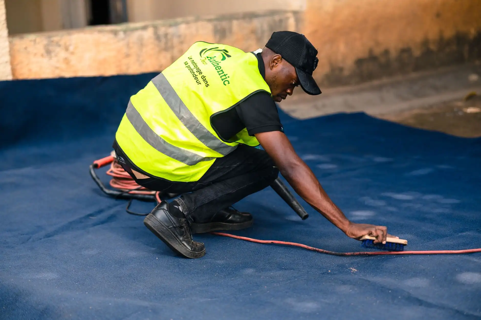 Technician in safety vest deep-cleaning carpet