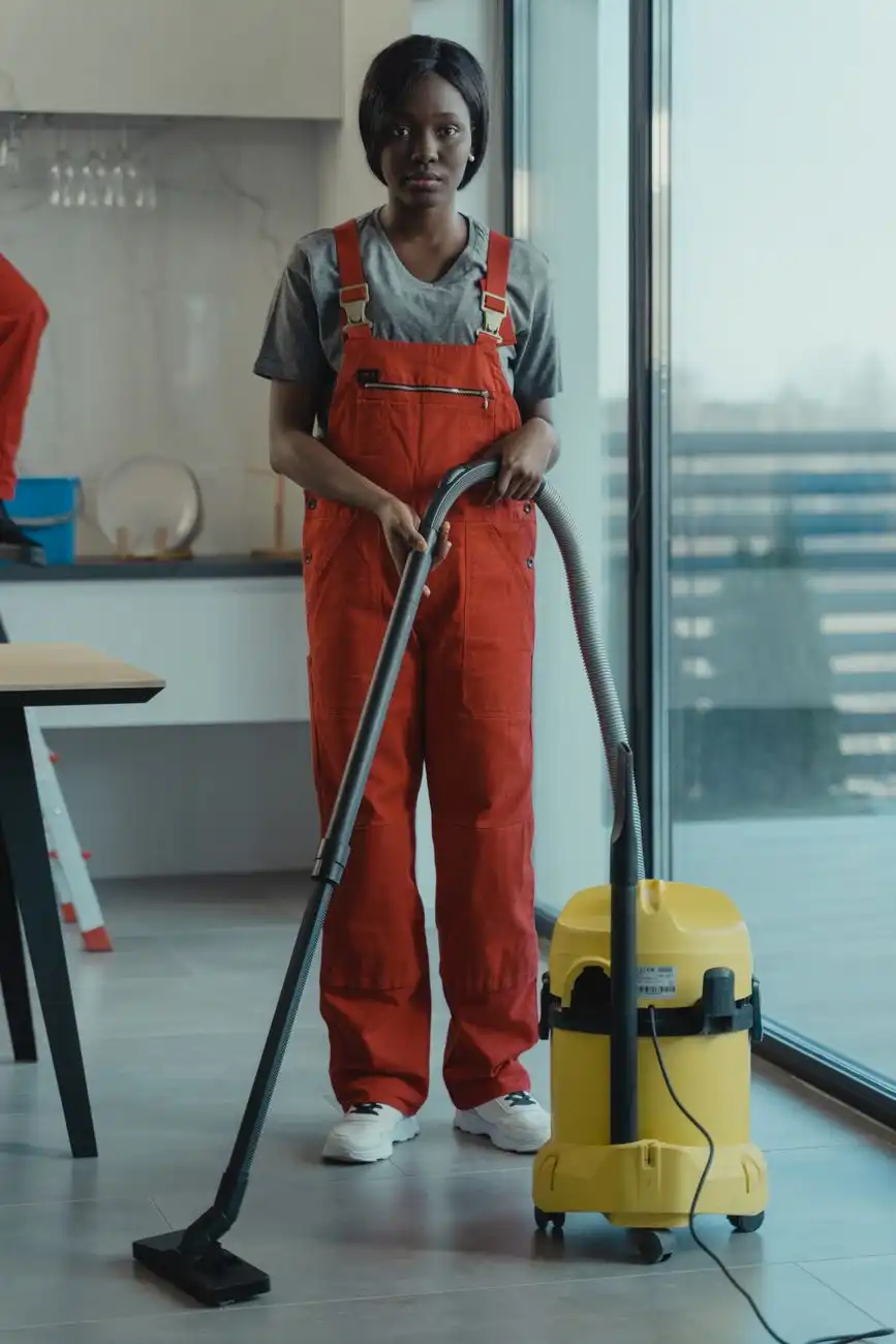 Cleaning technician in coveralls operating a professional wet vacuum